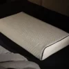 Ein einzelnes Bodypur-Kissen in Seitenansicht auf dunklem Hintergrund, mit Fokus auf die strukturierte Oberfläche und die Umrandung des Kissens.